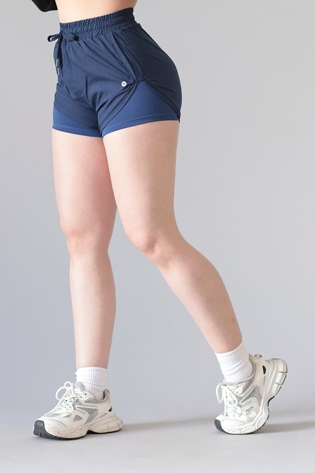 Short deportivo femenino con sobrecapa cruzada